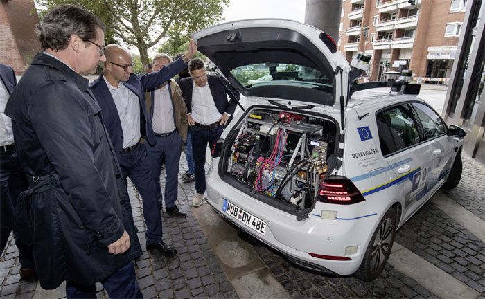 Bundesverkehrsminister Scheuer (links) informiert sich über die Testfahrten der automatisierten e-Golf Flotte in Hamburg: rechts, Leiter Volkswagen Group Innovation, Axel Heinrich.