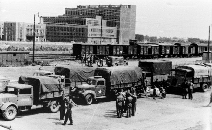 US-Truppen am Bahnhof von Wolfsburg mit dem Kraftwerk des Volkswagenwerks im Hintergrund.