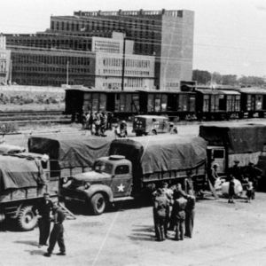 US-Truppen am Bahnhof von Wolfsburg mit dem Kraftwerk des Volkswagenwerks im Hintergrund.
