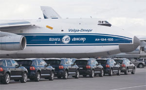 Porsche Cayenne-Fahrzeuge vor einer Antonov 124-100